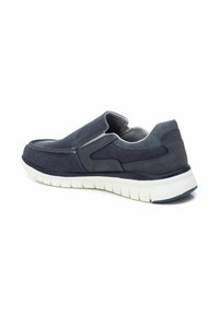 Zapato slip-on azul marino con parte superior de textil y cuero. Presenta un panel elástico texturizado y una suela flexible blanca. Detalles de costura mínimos.