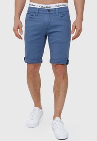Plave traper kratke hlače s prevrnutim rubom, s kopčanjem na gumbe, prednjim i stražnjim džepovima, te strukom s logotipom Calvin Klein.