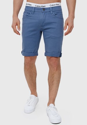 Shorts en denim bleu avec un ourlet roulé, dotés d'une fermeture à bouton, de poches avant et arrière, et d'une taille avec logo Calvin Klein.