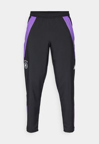 Zwarte sportbroek met paarse zijkanten, voorzien van een elastische tailleband en een geborduurd logo met sterren op het onderste deel van het linkerpoot.