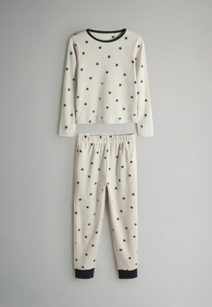 Piżama z długim rękawem w kremowym kolorze z czarnym wzorem gwiazdek; zawiera bluzkę z okrągłym dekoltem oraz spodnie z elastycznym pasem i czarnymi mankietami.
