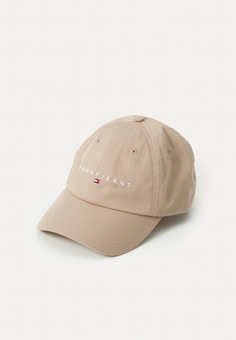Beige baseball cap med buet skygge, lavet af glat stof, med "TOMMY JEANS" broderet i hvid. Inkluderer ventilationshuller.