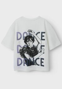 Hvid kortærmet t-shirt med et grafisk design af en danser med volanger og "DANCE" tekst i blå og lilla farver.