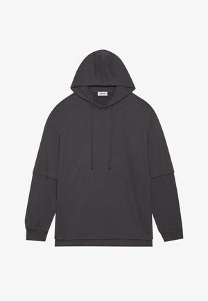 Pelēkā ogļu krāsa kapuci cepure ar garām piedurknēm, auklām ap kaklu un brīvu piegriezumu. Gluda, maiga auduma struktūra bez redzamām dizaina apdrukām.