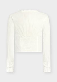 Bílá halenka s dlouhým rukávem, volánkovým límečkem, zadním dílem s nařasenou možností úpravy a manžetami na knoflíky s jemným krajkovým proužkem.