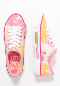 Baskets multicolores avec un motif tie-dye aux teintes roses et jaunes, lacets blancs et semelle en caoutchouc texturée avec des bandes colorées.