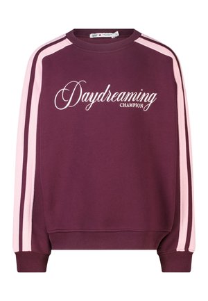 Sweat-shirt bordeaux avec des rayures rose clair sur les manches et un texte blanc en cursive "Daydreaming Champion" sur le devant.
