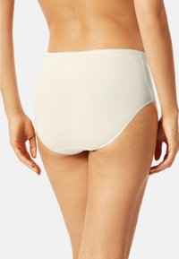 Slip in cotone color beige chiaro con bordi senza cuciture. Presenta una forma a vita alta e una texture liscia, adatta per l'uso quotidiano.