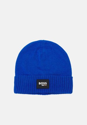 Bonnet en tricot bleu avec un revers côtelé, doté d'une étiquette noire rectangulaire avec le nom de la marque "BOSS" en blanc et des accents colorés.