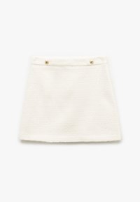 Hvid mini nederdel lavet af struktureret stof, med lige snit, guldknapdetaljer ved taljen og en ren kant.