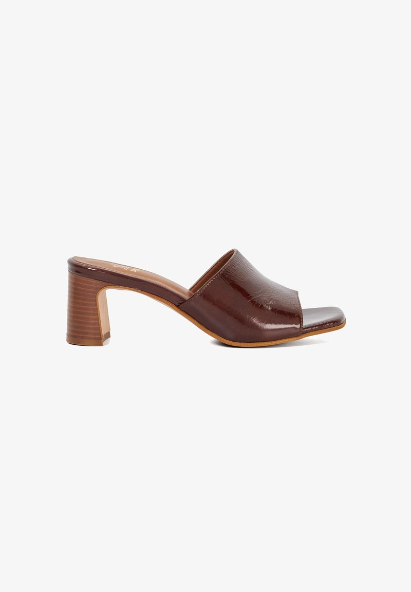 Brown leather open-toe mules with a glossy finish, featuring a slightly curved silhouette and a chunky, ribbed heel.