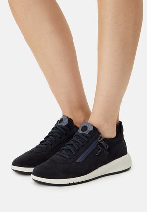 Navy suede sneakers with a white rubber sole, rounded toe, lacing, side zipper, and mesh accents for breathability.