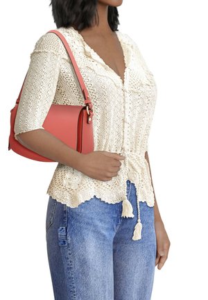Crocheted, off-white blouse with a v-neck, 3/4 sleeves, and tassel detail. Paired with a coral handbag and denim jeans.