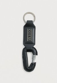Portachiavi in pelle nera con anello metallico argento e chiusura a moschettone. Presenta il logo "GUESS" impresso su una targhetta rettangolare.
