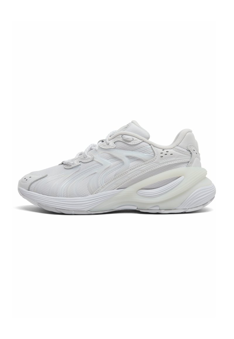 Scarpe sportive in rete bianca e materiale sintetico, con punta arrotondata, dettagli testurizzati e suola ammortizzata con un design ondulato.