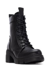 Botín de cuero negro hasta el tobillo con punta redonda, cordones en la parte delantera y tacón ancho. Presenta una cremallera lateral y un acento decorativo de hardware.