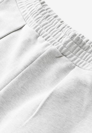 Šedé bavlnené tepláky s elastickým pásom, s bočnými vreckami a mäkkou, textúrovanou tkaninou pre pohodlie.