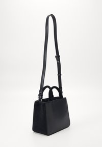 Schwarze Handtasche mit strukturiertem Design aus glattem Leder und Wildleder, zwei oberen Griffen und einem verstellbaren Tragegurt.