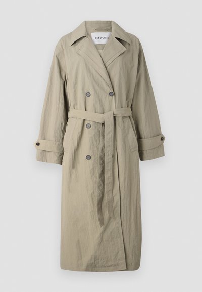 Beige double-breasted trench coat with a tie belt, buttoned cuffs, and a slightly textured fabric. Features a notched collar and two front pockets.