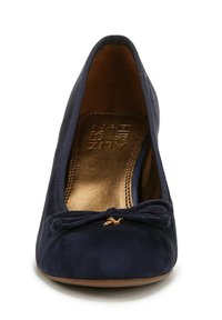 Scarpa piatta in suede blu navy con punta arrotondata, caratterizzata da un piccolo fiocco dorato e una soletta metallica dorata. Texture liscia, design semplice.