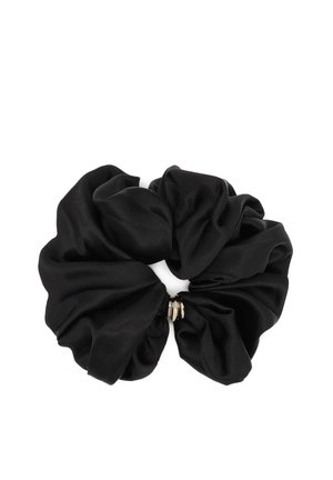 Schwarzes Satinscrunchie mit goldenem Metallelement in der Mitte, auf weißem Hintergrund in weichen, gesammelten Falten drapiert.