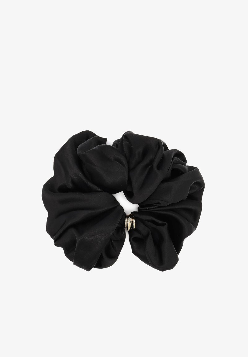 Chouchou en satin noir avec détail en métal doré au centre, disposé en plis doux et froncés sur un fond blanc.