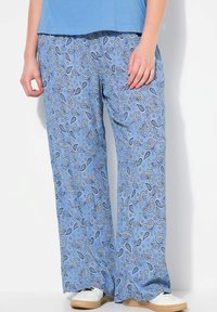 Pantalones de paisley de color azul claro en un diseño holgado y de pierna ancha. La tela presenta patrones en azul oscuro y blanco con sutiles acentos amarillos.