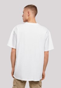 White cotton t-shirt with a loose fit, short sleeves, and a round neckline, showing the back view with a smooth texture.