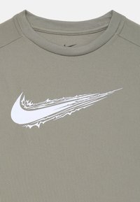 Sudadera deportiva gris con un tejido texturizado, que presenta un logo de Nike blanco en un diseño dinámico en el área del pecho izquierdo.