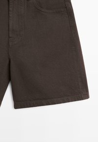 Donkerbruine denim short met voorzakken en zichtbare naden op een witte achtergrond.