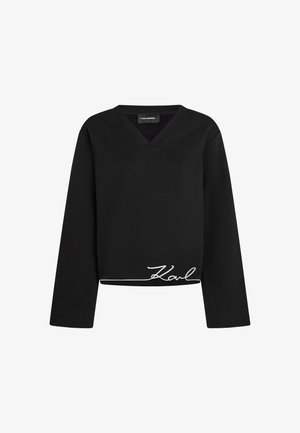 Sweatshirt cropped preto com mangas longas, design de decote em V e detalhe da assinatura branca "Karl" na parte inferior. Material suave com uma texture lisa.