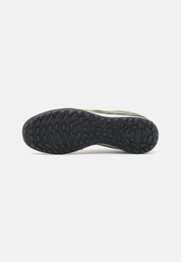 Suela de goma negra con patrón de agarre texturizado; diseño minimalista con acentos en verde y gris; bordes redondeados para mayor flexibilidad.