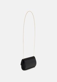 Black clutch bag with a smooth leather body and a suede flap. Features a gold chain strap, rounded shape, and minimalistic design.