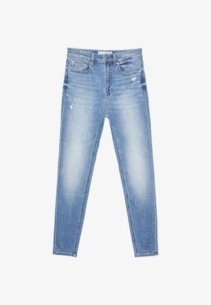 Jasnoniebieskie dżinsy o slim fit, z lekkimi przetarciami, pięcioma kieszeniami oraz zamocowanymi detalami wzdłuż szwów.