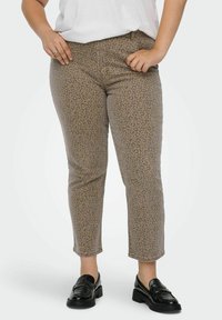 Kratke hlače s leopard uzorkom u svijetlosmeđoj boji s tamnosmeđim točkama. Struk srednjeg rasta i uski kroj, uparene s crnim mokasinama.