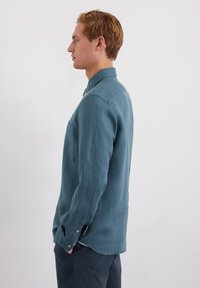 Lichtgewicht, lange mouwen overhemd in een donkerblauwe kleur, met een button-down kraag, een enkele borstzak en knopen bij de manchetten.