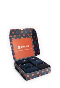 Set von dunklen Socken in einer gemusterten Schachtel mit roten Punkten. Die Schachtel hat ein oranges Etikett und verspielte Tiergrafiken im Inneren.