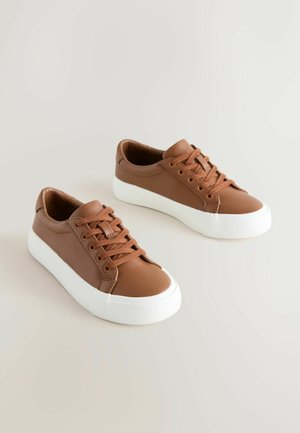Hnedé kožené tenisky s hladkou textúrou, okrúhlym špičkou, bielou gumovou podrážkou a zodpovedajúcimi šnúrkami. Minimalistický dizajn bez viditeľného loga.