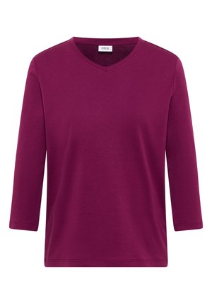 Haut à col en V et manches trois-quarts en mélange de coton bordeaux profond, avec une texture lisse et une coupe régulière. Étiquette de marque "CECI" au niveau du col.