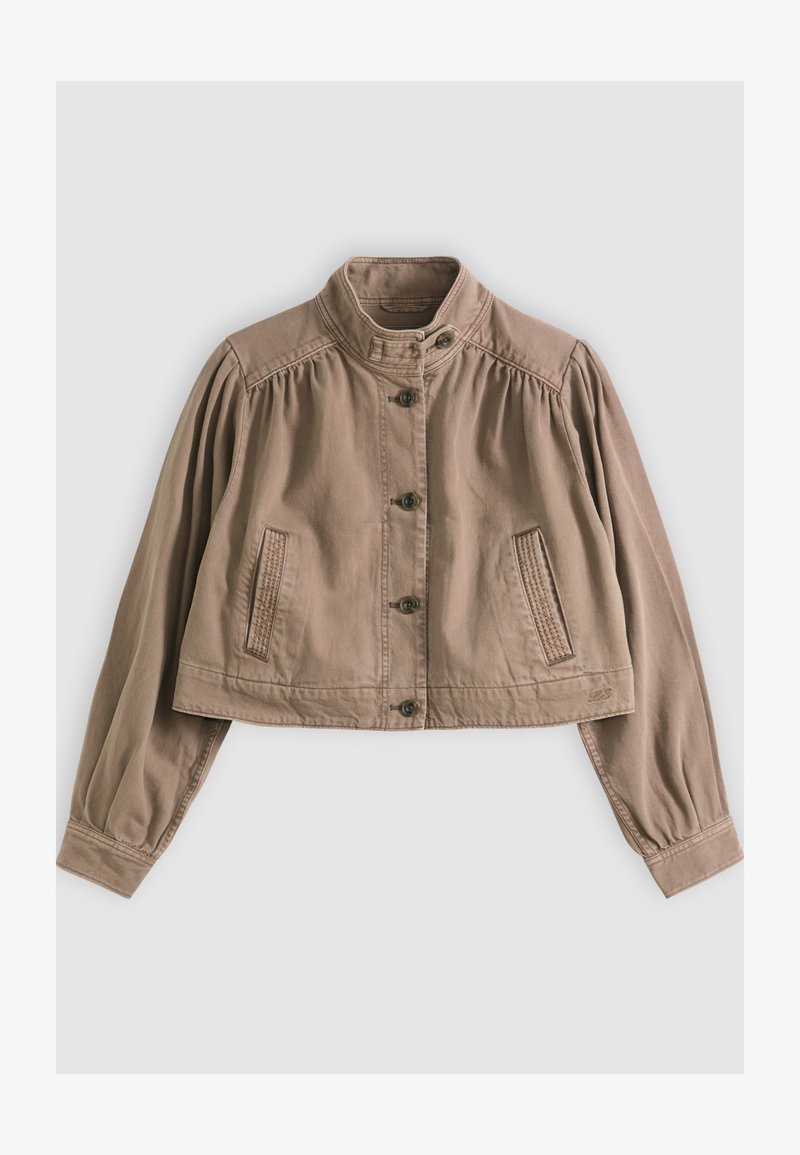 Chaqueta corta de color marrón claro con cuello alto, cierre de botones, mangas largas abullonadas y detalles de bolsillos cosidos sobre un fondo neutro.