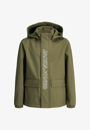 Veste vert olive avec capuche et lettrage blanc, superposée sur un pull bleu marine, associée à un pantalon noir et des baskets gris clair.