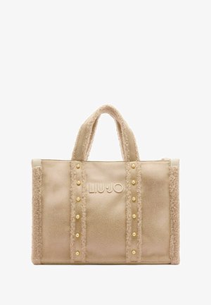 Borsa a tote beige con tessuto testurizzato, caratterizzata da bordi morbidi, borchie in tono oro e logo goffrato. Doppi manici per un facile trasporto.