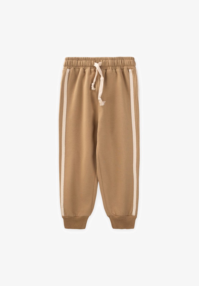 Pantalons de survêtement beige avec une taille élastique et un cordon de serrage, dotés de deux bandes blanches sur les côtés et de poignets côtelés au niveau des ourlets.