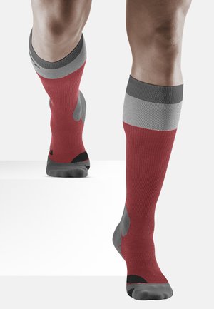 Kniestrümpfe mit rotem Körper, grauen gerippten Bündchen und kontrastierenden grauen Fersen- und Zehenbereichen; strukturiertes und enganliegendes Design.