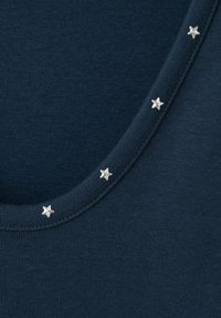 Marineblaues Stoffoberteil mit rundem Ausschnitt, verziert mit kleinen silbernen Sternen entlang des Kragens. Glatte Textur.