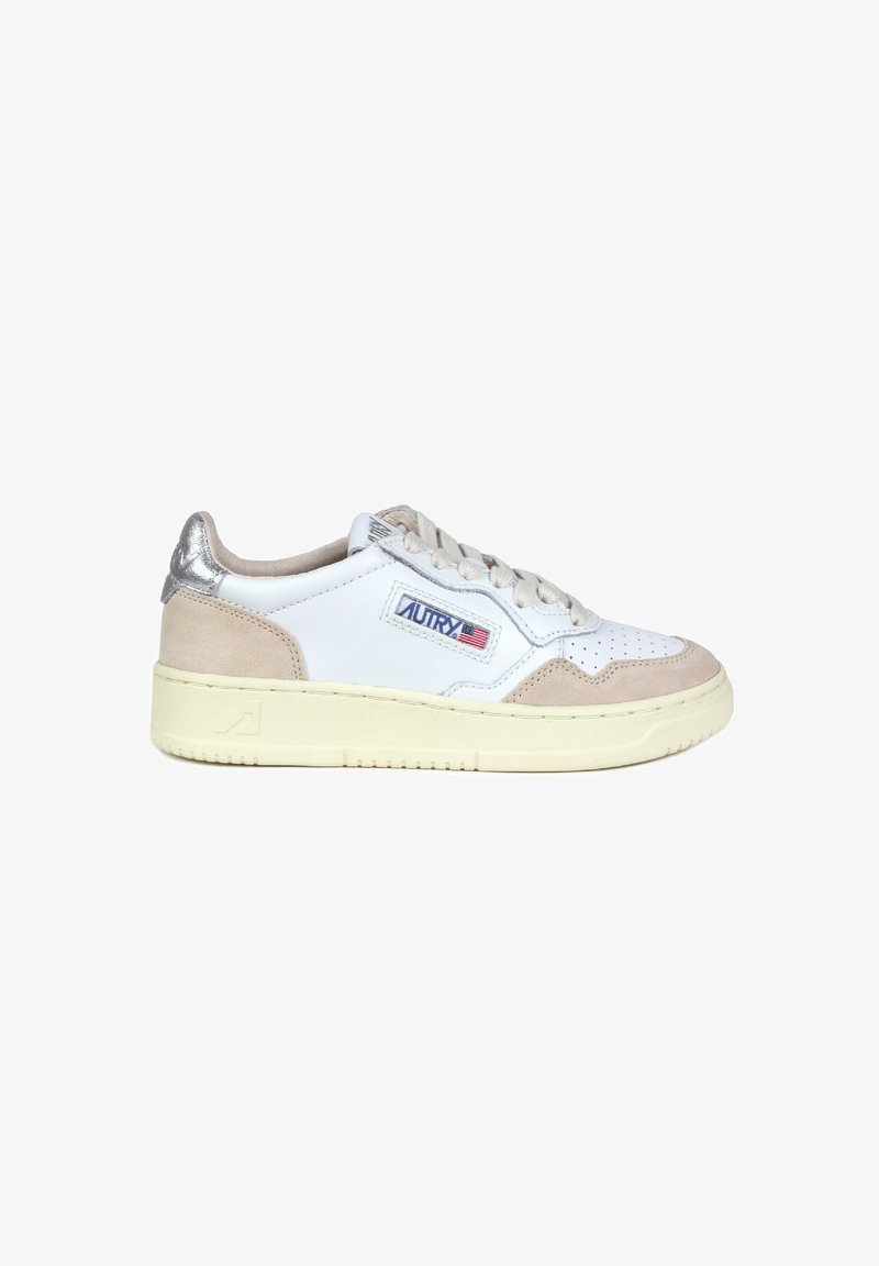 Sneaker bianco con accenti in suede grigio, design perforato e tab di tallone argentato. Presenta chiusura con lacci e una suola spessa di color crema.