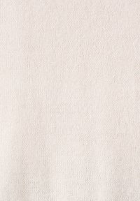 Lichtbeige gebreide stof met een zachte textuur. Het oppervlak heeft een glad, gelijkmatig patroon en minimale kleurvariaties.