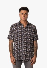 Camisa de botones de manga corta en tonos oscuros con un estampado de calaveras y hojas de palma. Confeccionada en tela ligera y de corte holgado.
