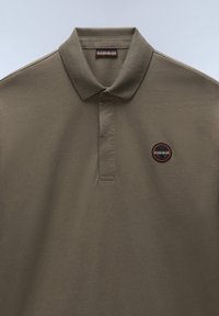 Olijfgroen polo shirt van katoenmix, met een kraag, knoopsluiting en een rond logo-embleem in zwart en oranje op de borst.