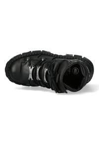 Schwarzer Leder-Hochschuh mit strukturiertem Sohlen, ausgestattet mit silbernen Beschlägen und schwarzen Schnürsenkeln. Größe 40 innen markiert.